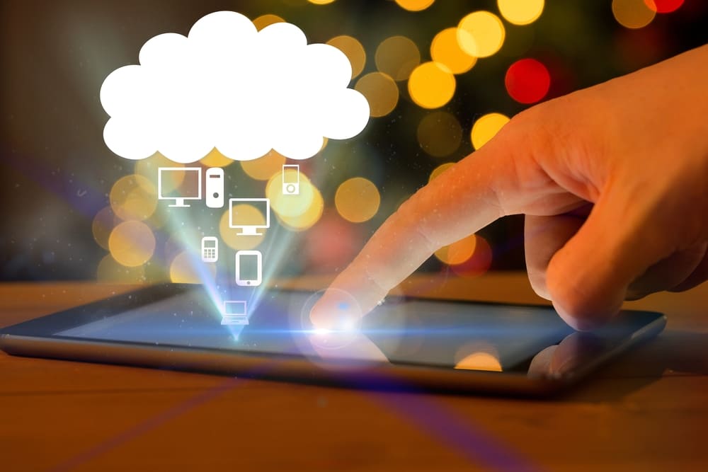 dito che usa smartphone con icona cloud e computer